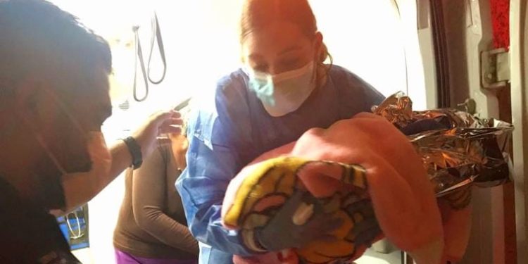 Paramédicos de SUMMA atienden a mujer en labor de parto durante traslado a hospital.